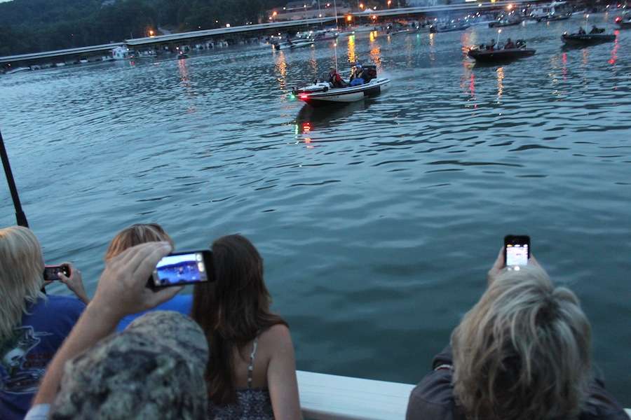Fans crowd the edge of the dock, snapping pics of their favorite anglers. 