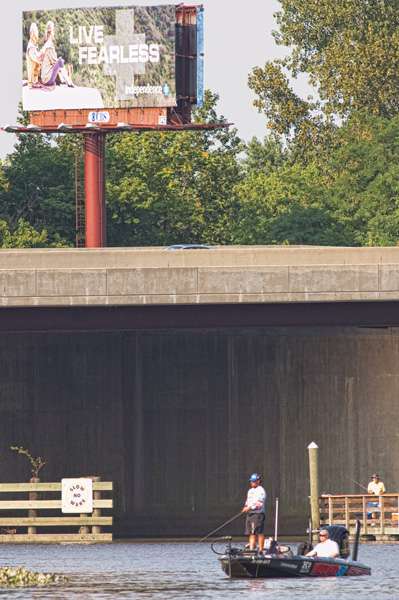 Behind him, Cliff Crochet fishes under a billboard that personifies many of these anglers.
