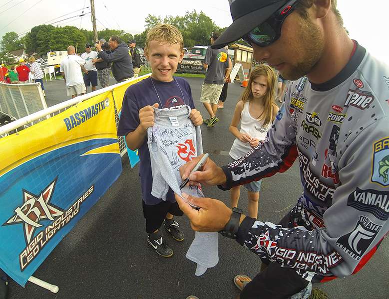 Brandon Palaniuk takes the time to sign an autograph for a young fan. He is sitting in 9th place.