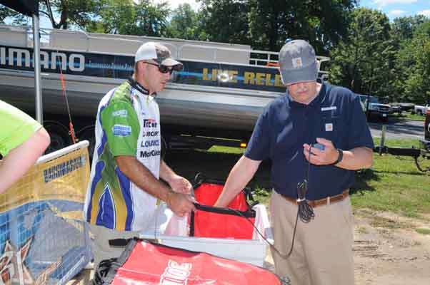 B.A.S.S. Nation Conservation Director Gene Gilliland monitors the water temperature in the weigh-in bags with some assistance from Chip Swindell.