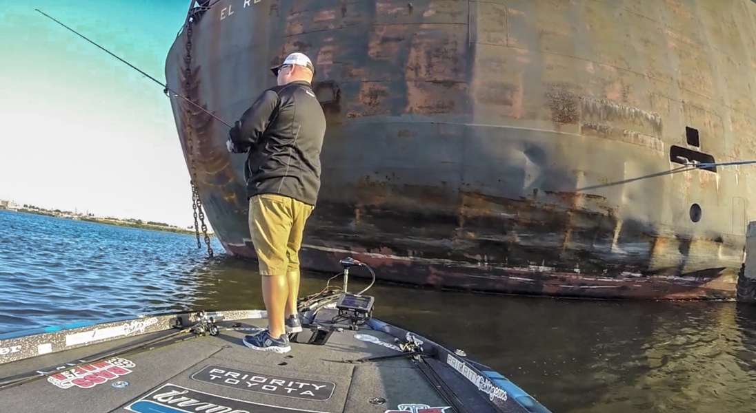 Jacob Powroznik fishes in the shadow of a towering freighter on the Delaware. 