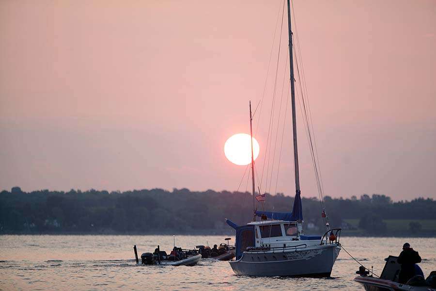 The sun rises as the last boats leave the basin. 
