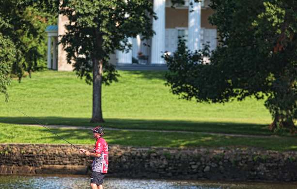 Britt Myers fishes in front of one of the many beautiful homes along the riverâs edge. 
