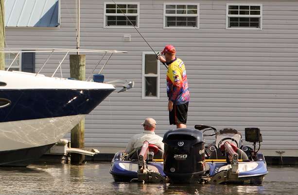 Keith Combs pitches a bait under a boat in a marina.
