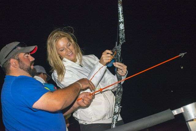 Guide Cory Vannederynen shows Emily Tucker how to properly reel in the line and prepare for the next carp shot.