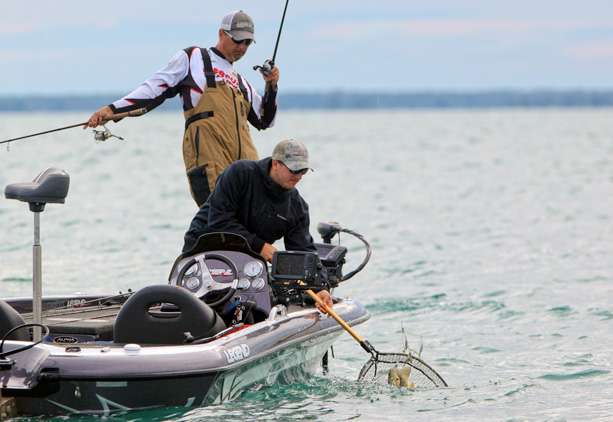 Nielsen moves a spinning rod from the deck of his boat to make room for Lonchar with the dip net.