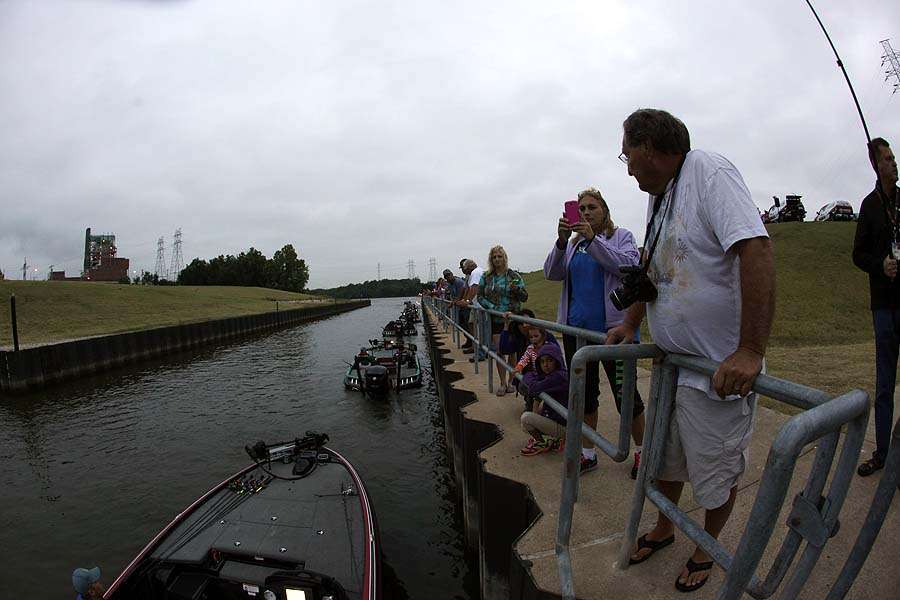 Fans and family line up along the seawall to see off the anglers. 
