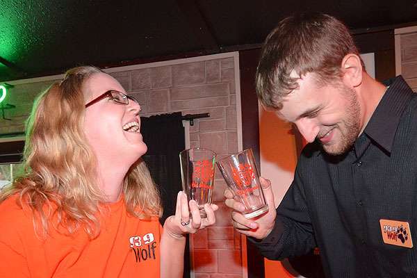 Wolf Radioâs Carrie Leigh and Alex Womer toast each other with Old Milwaukee beer tumblers.