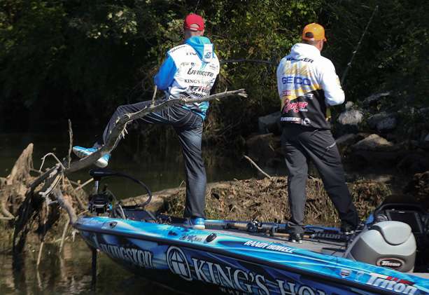 Howell holds the boat in place while he and Walker pick apart a piece of cover. 
