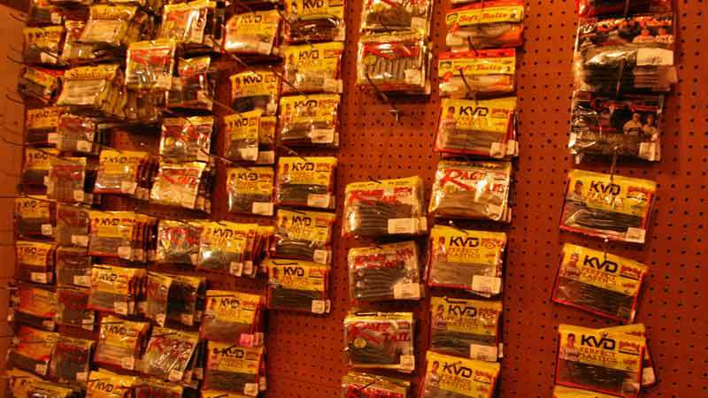 A pegboard holds bags and bags of soft plastics, in all sizes and colors.