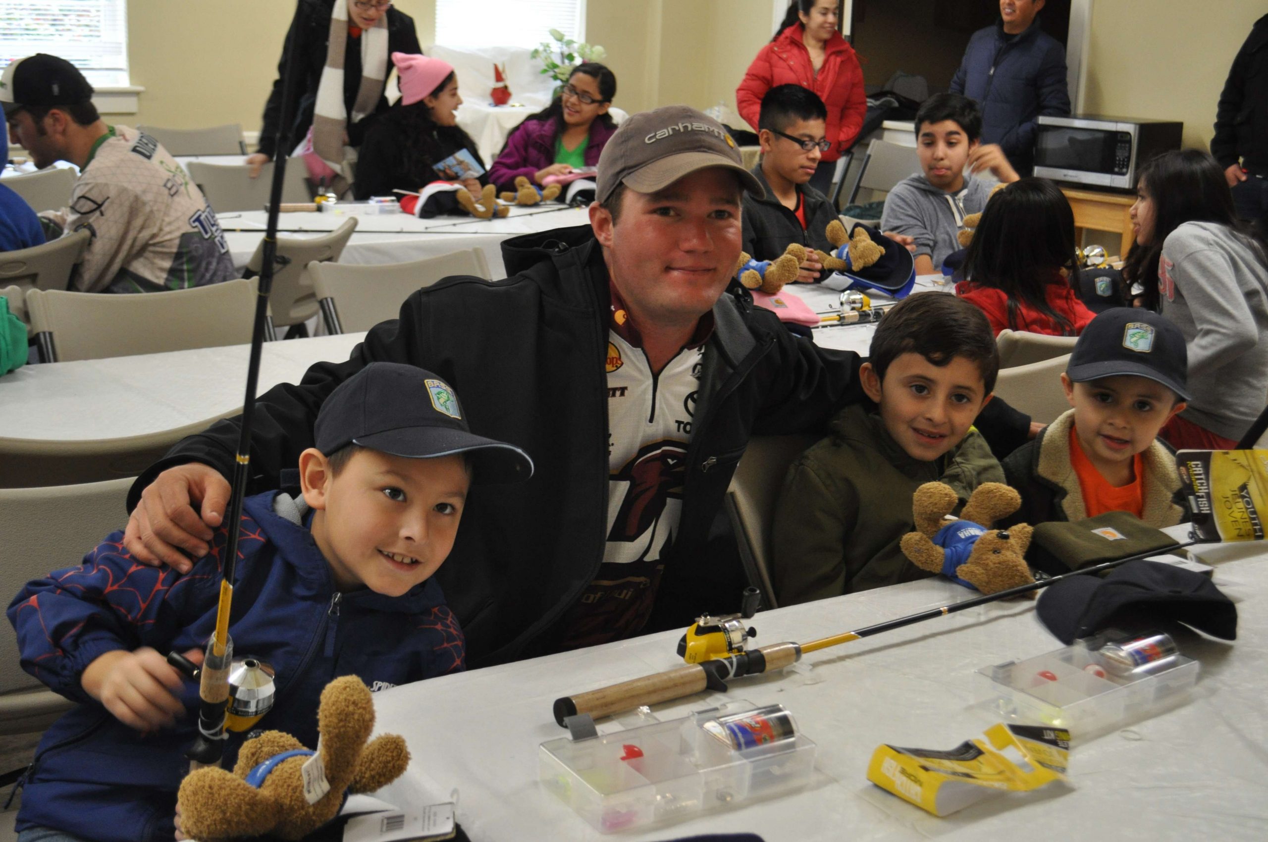 Carhartt Bassmaster College Series Classic qualifier Brett Preuett leans in for a photo opportunity with a group of students.