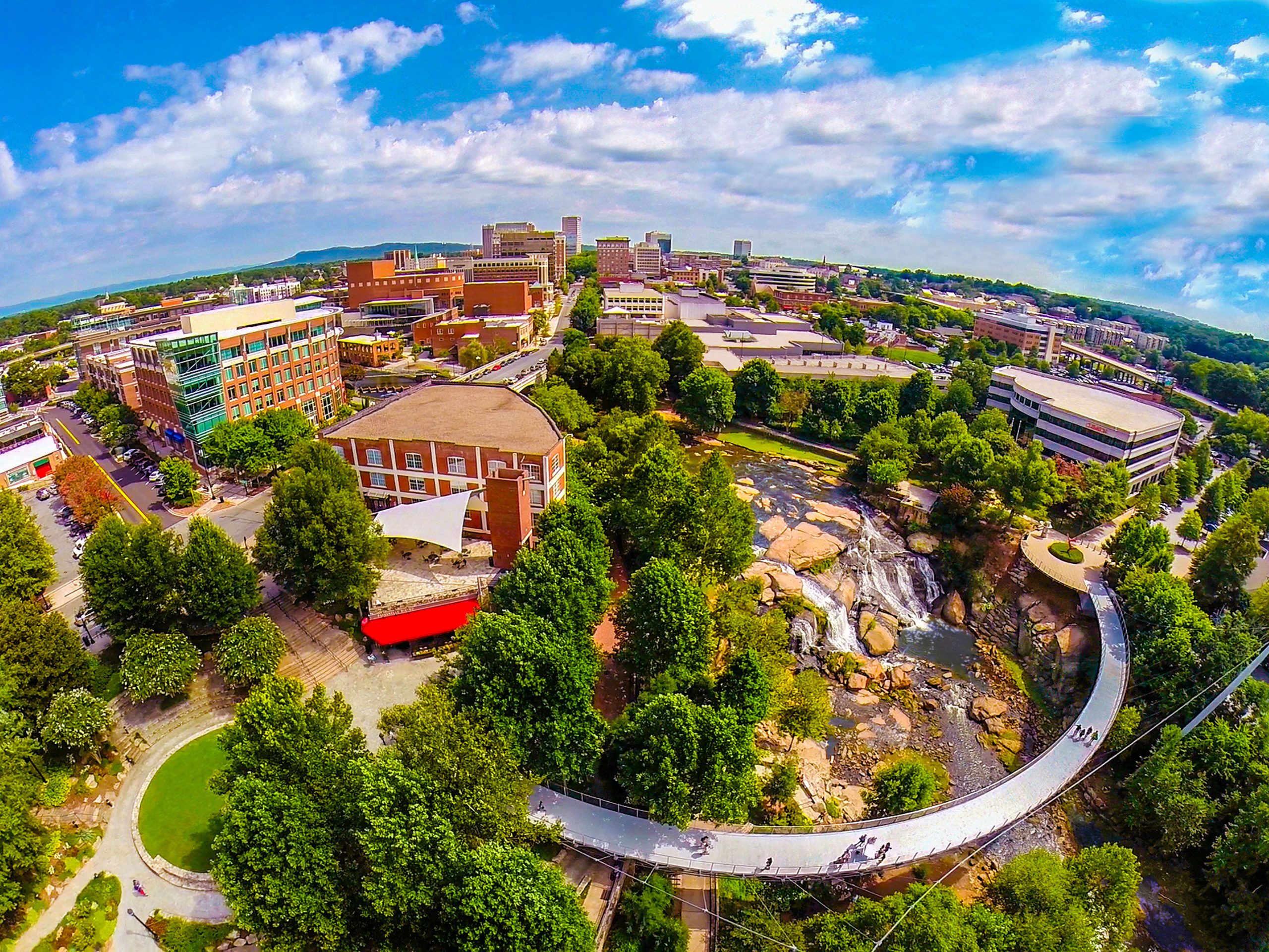 The host for the 2015 GEICO Bassmaster Classic is Greenville, S.C. This aerial view of downtown Greenville shows Liberty Bridge at Falls Park on the Reedy. This wooded valley park is less than a mile away from the arena that will host the Classic weigh-ins.