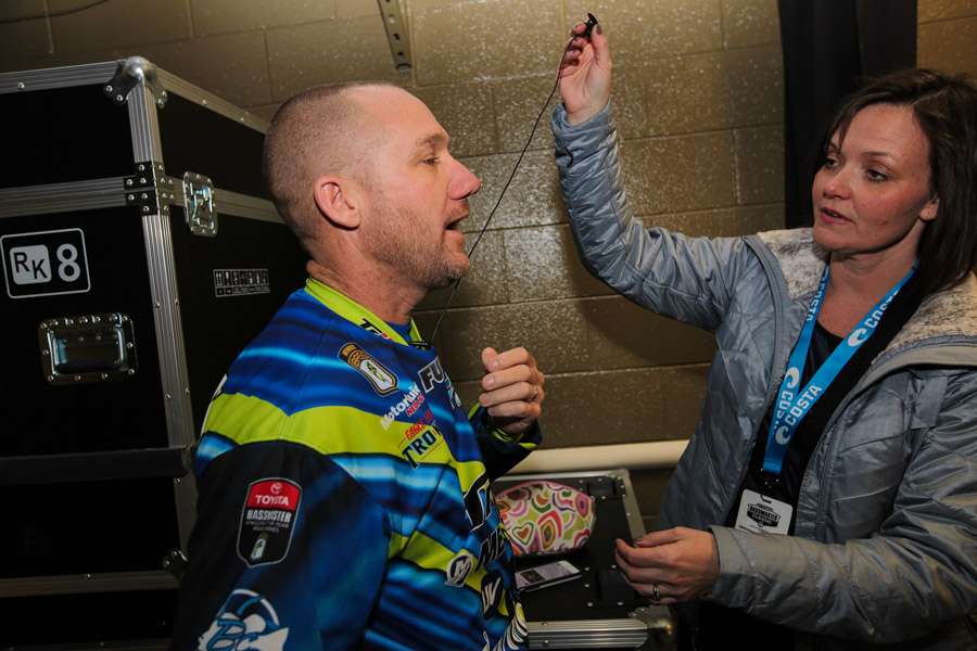 Brent Chapman's wife, Bobbi, hooks up a microphone to Chapman for his backstage tour of the arena at the 2015 GEICO Bassmaster Classic presented by GoPro.