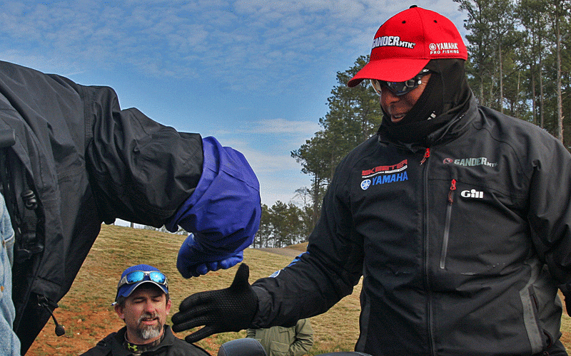 Dean Rojas gets a fist bump from Max Leatherwood, who is running the check station at Green Pond Landing.