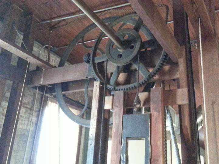 ...this historic elevator doesn't have button, it used to be lifted and lowered, elevorated, by people pulling up an down on the ropes that ran through those wheels up until they got it...
