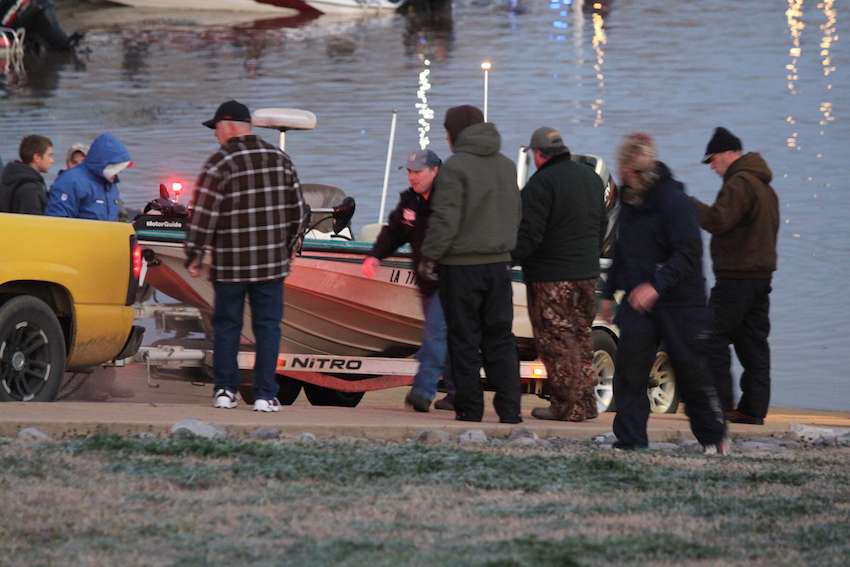 Tournament Manager Hank Weldon and others assist one team in putting their boat back on the trailer. Apparently the anglers unhooked their boat a little early and it slid off the icy trailer shy of the water. 