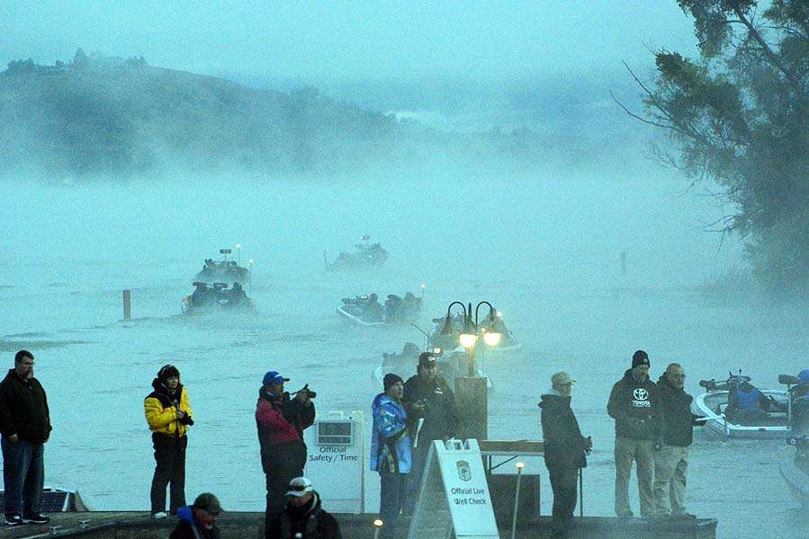 The fog rolls in as the boats idle safely out into the lake. 