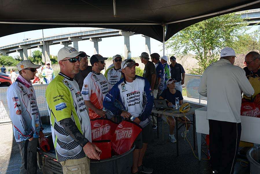 The first flight of anglers wait their turn at the weigh-in scales. 