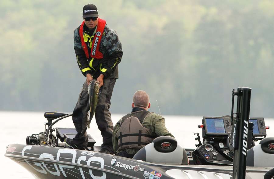 Ehrler moves to the front of the boat to his trolling motor while removing the hooks from the fish. 
