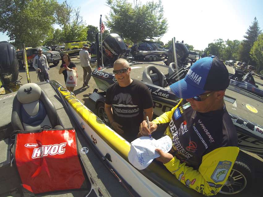 Bobby Lane signs an autograph before bagging his fish.