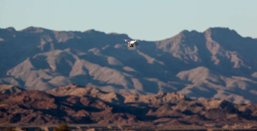 A drone flies overhead.