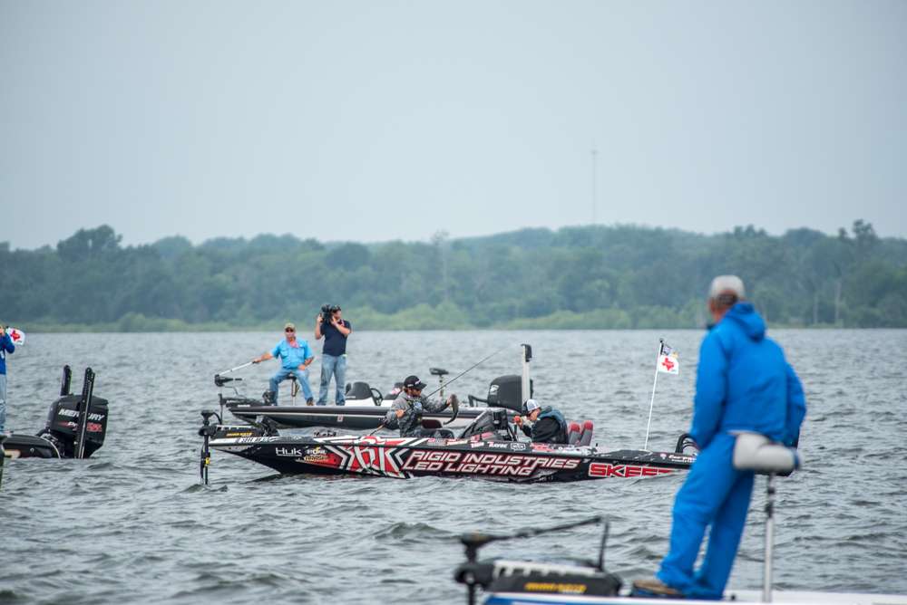 In the midst of all the other anglers and spectators Palaniuk hooks a fish and boats it. 