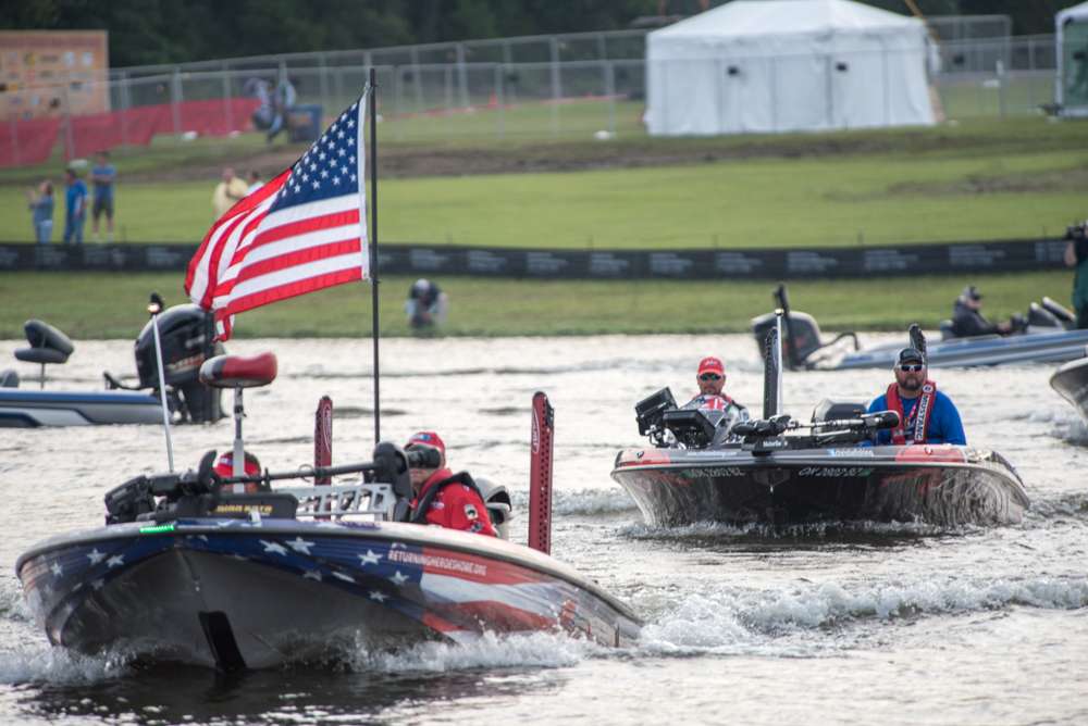 The flag boat escorts leader Jason Christie out to the takeoff zone on Memorial Day championship Monday. 