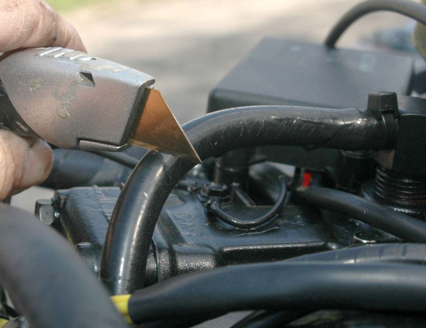 <em>INSTALLING A WATER PRESSURE GAUGE</em>
<br>The best place to cut into the engine's cooling system was this water line at the top fo the engine in the V between the cylinder heads.