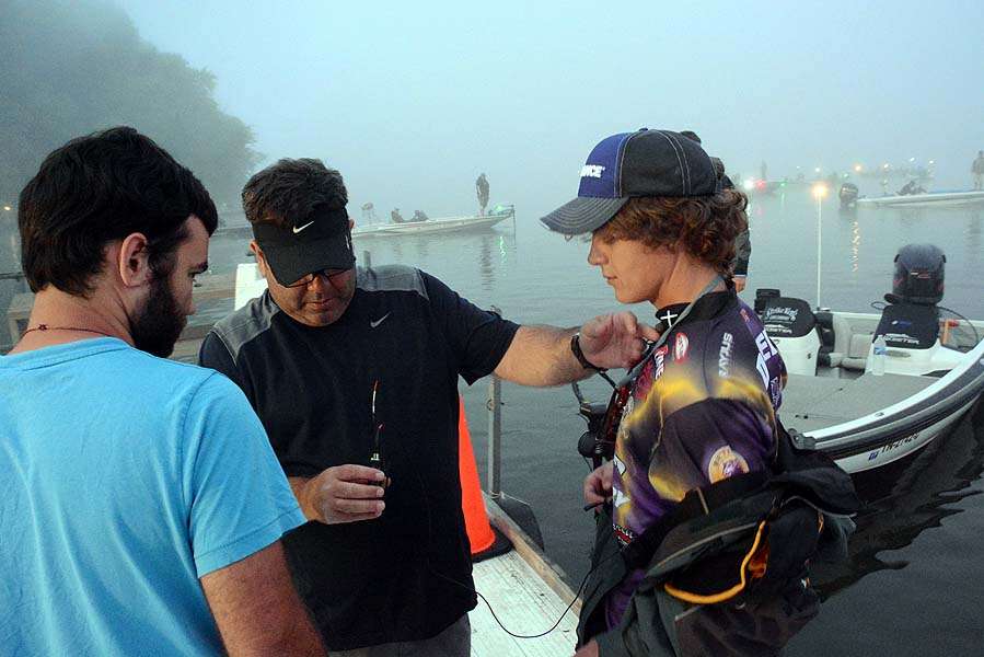 The Bassmasters TV crew rigs a wireless microphone to this angler. Crews will follow the top three teams for an episode of the show. 