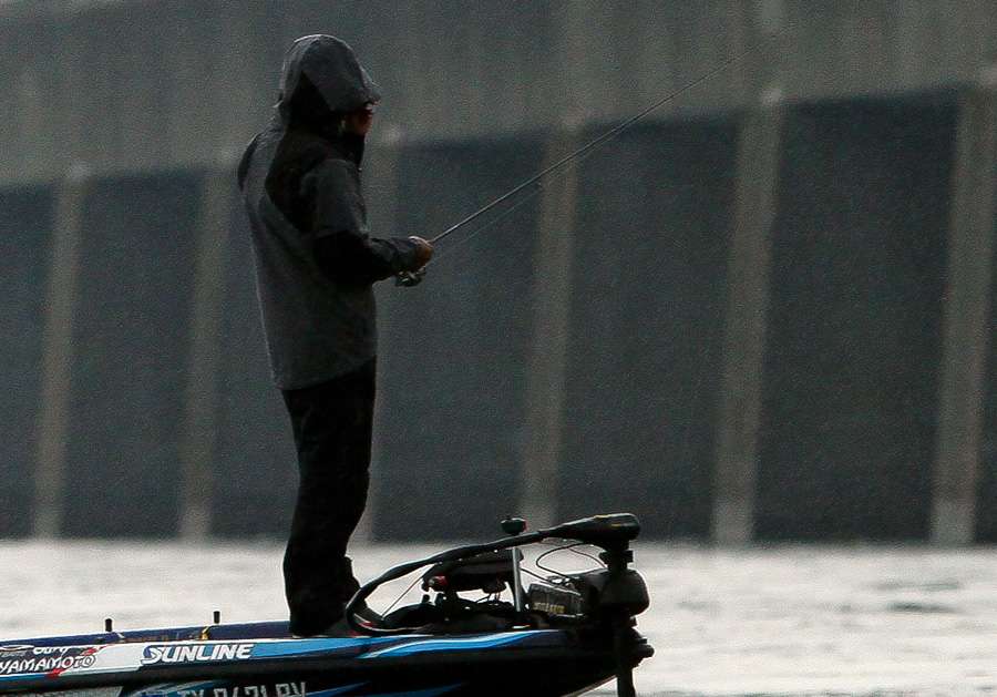 Ken Iyobe pulls the hood of his rain suit farther over his head as a heavy rain settled over the St. Lawrence River.  