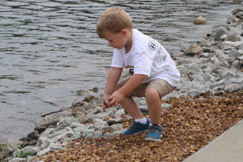 A young fishing fan plays in the rocks...