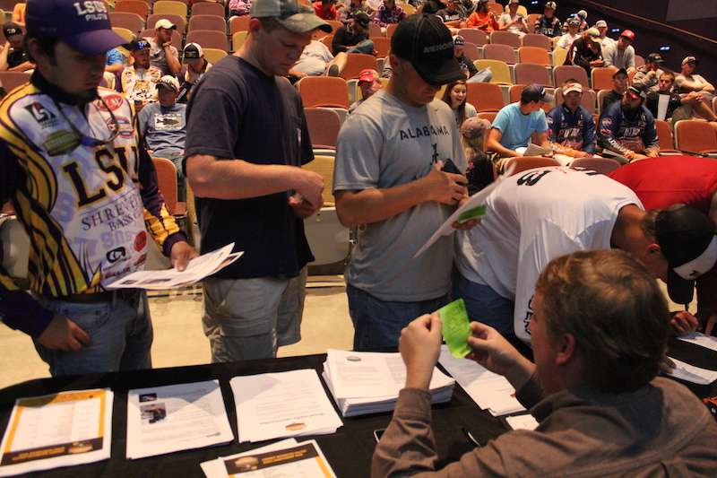 College series tournament director Hank Weldon checks the fishing licenses for anglers as they pass through registration. 