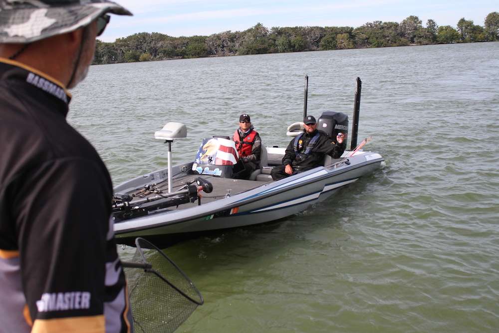 Anglers file through the check-in line and throw their float fobs into the check net.
