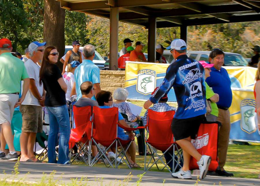 Gene Eisenman brings his fish to the scales while the crowd gathers to watch the Day One weigh in along the shores of Lake Fort Gibson. 