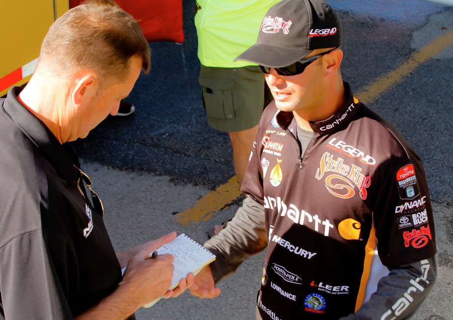 Bassmaster writer Craig Lamb takes notes while Matt Lee describes his eventful day on Table Rock Lake. 
