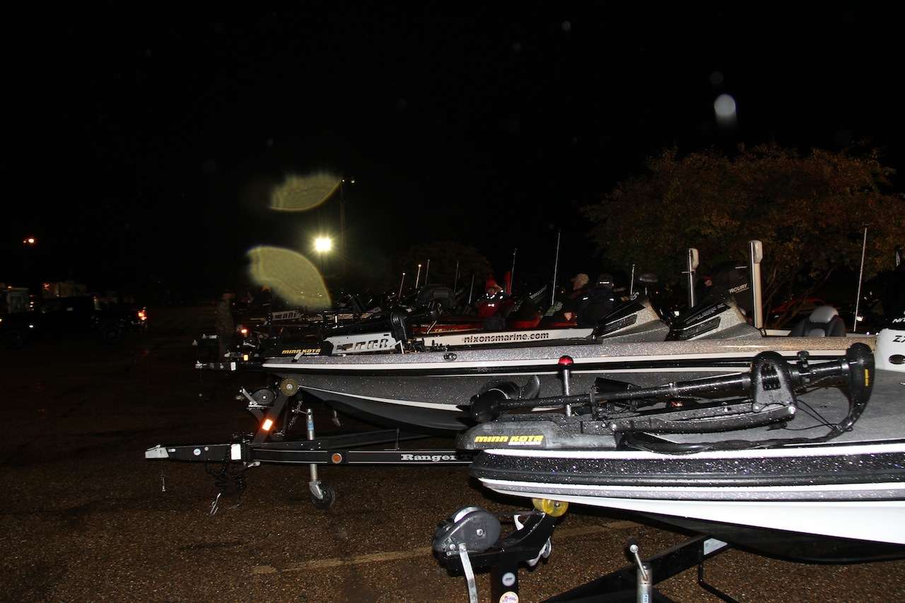 The boats are lined up on a rainy morning, waiting to get on the river.