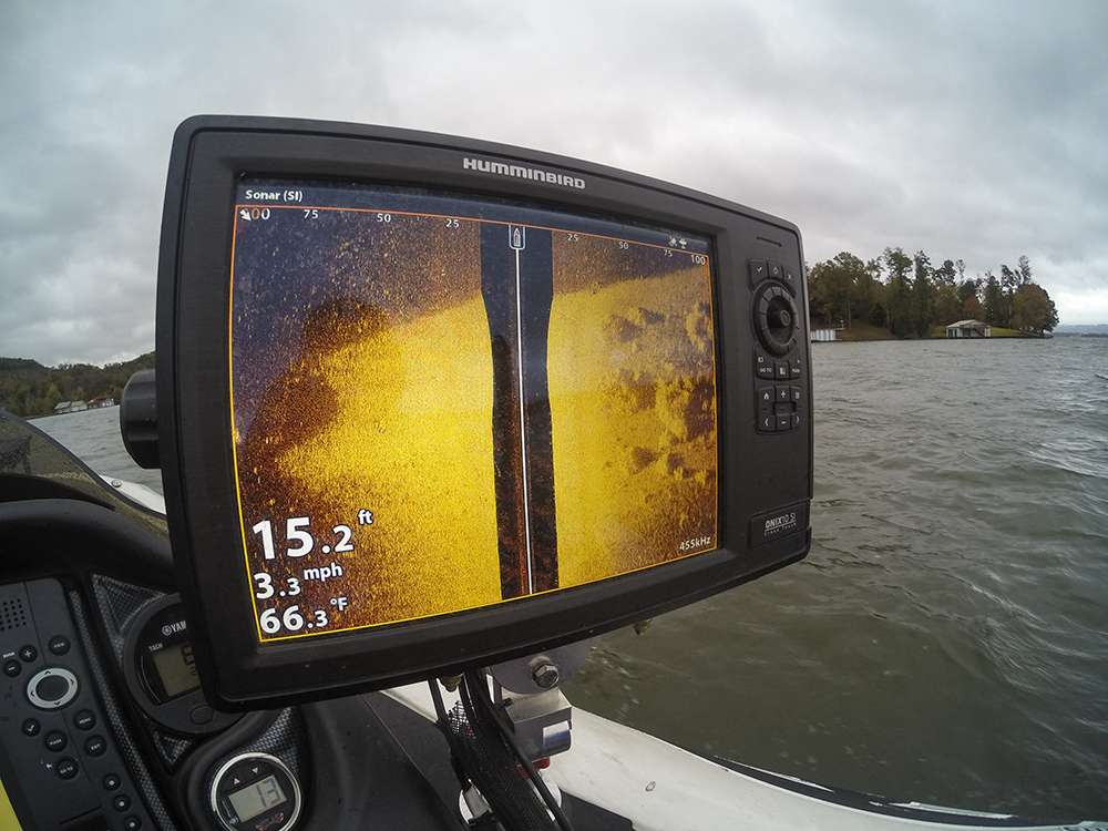 Through the use of the settings on the Humminbird Onix, he can set his Side Imaging to 100 feet on both sides, and still see structure clearly. In this photo Scroggins demonstrates a hard-bottom transition with patches of grass to the right-hand side. The brighter color indicates a hard bottom. On ledge lakes, like Guntersville, hard bottom is often key.