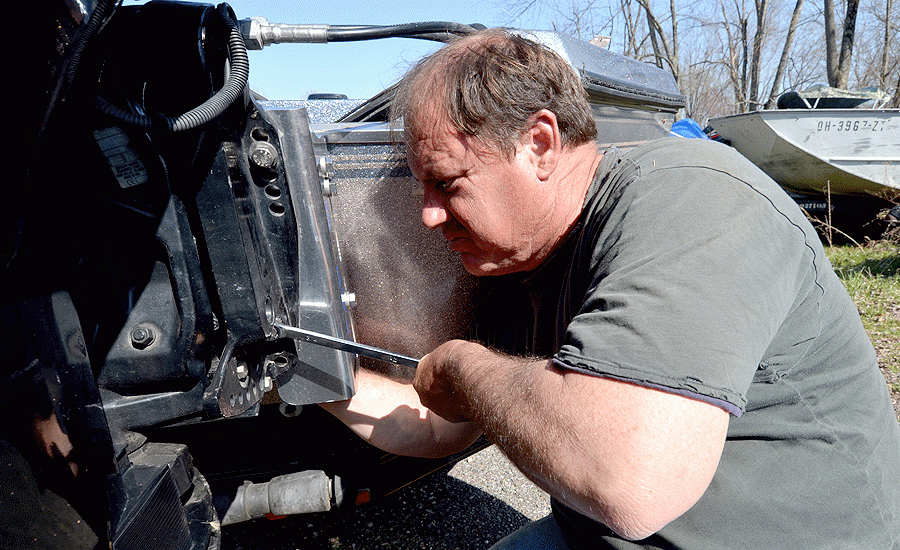 Schwarzel attaches the outboard to the jackplate with the new mounting bolts. Before he did this, he determined which holes in the outboardâs stern bracket would get the outboard close to the proper engine height.