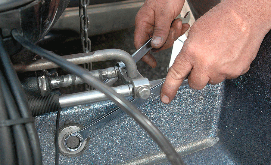Schwarzel removes the nuts from the outboardâs top two mounting bolts, which are accessible in the splash well.