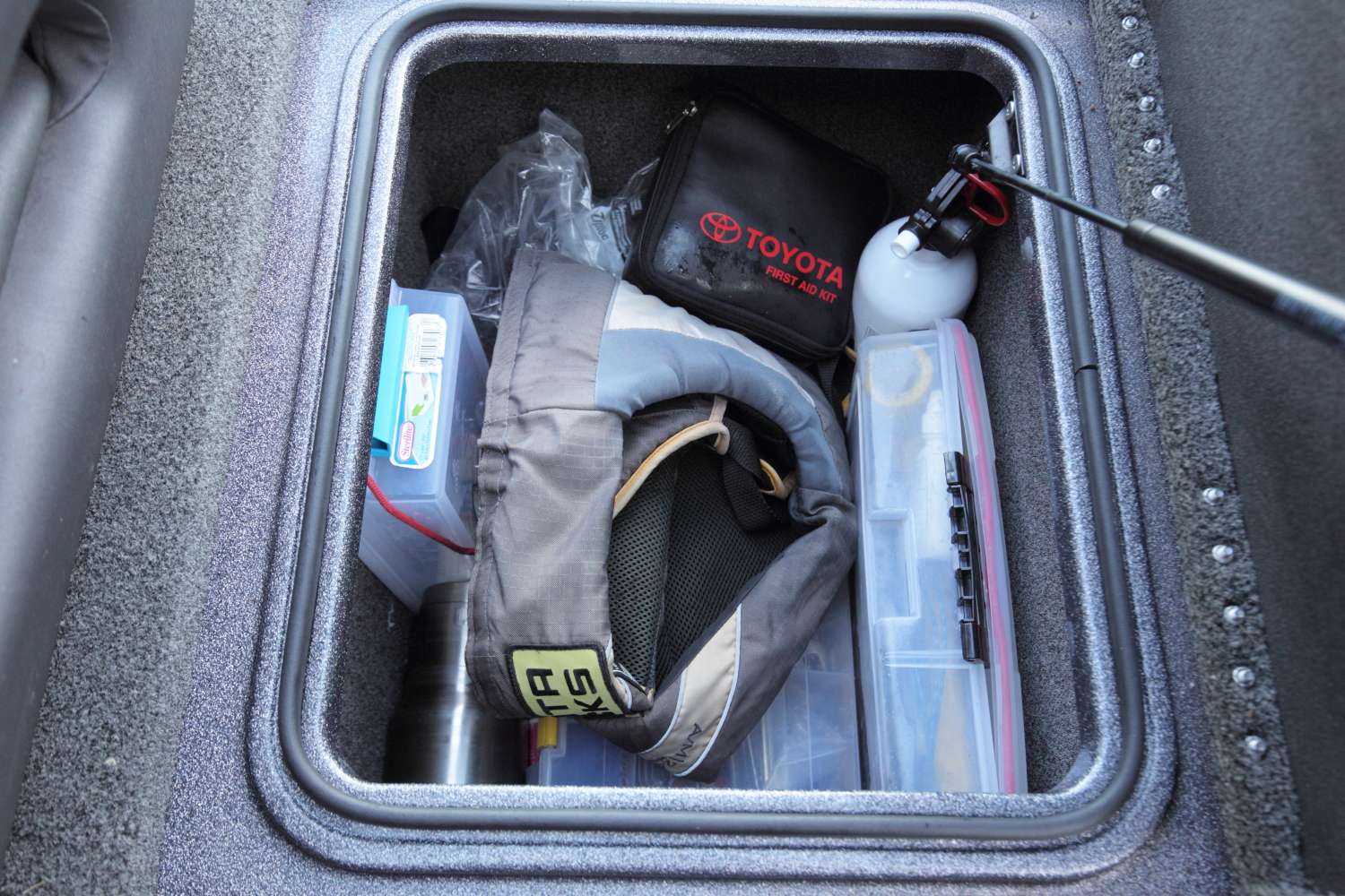One rear box holds two Plano boxes, a first-aid kit, a life jacket, an extra trolling motor prop, clothes, a fire extinguisher and an extra hub assembly kit.