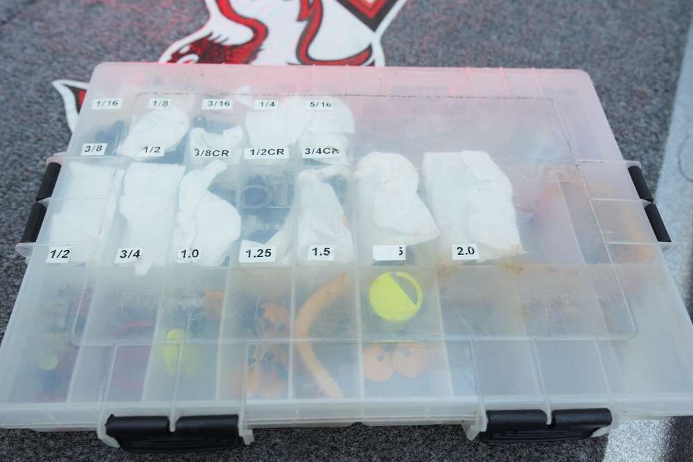 A clear plastic box is used to store Lucas' weights. The different weight compartments are labeled on the outside of the box.