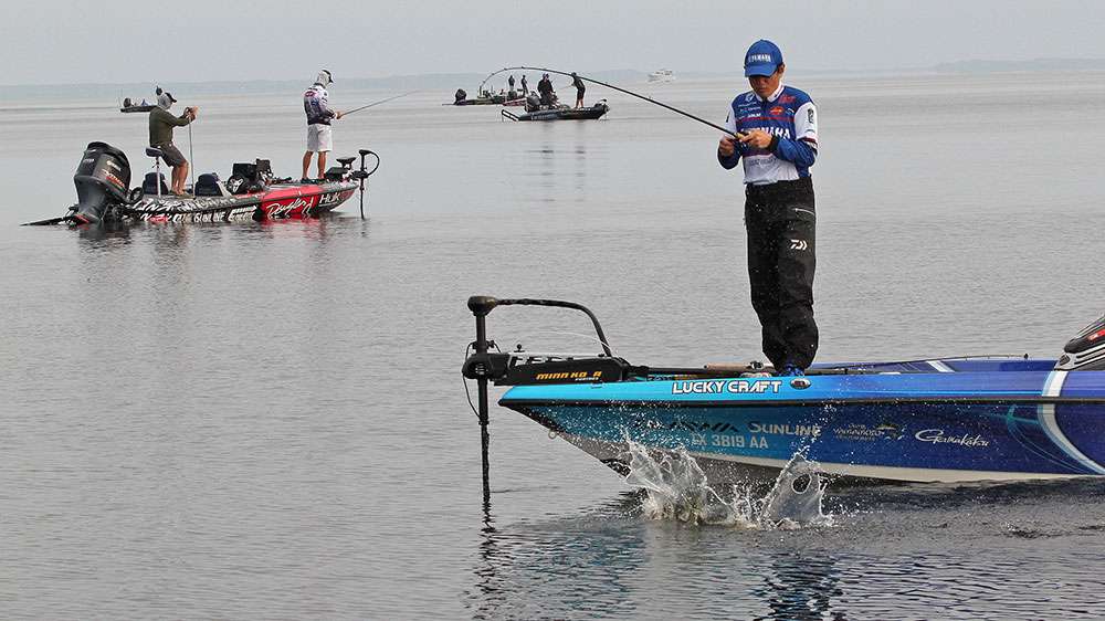 Takahiro Omori gets a fish up to the side of his boat. 