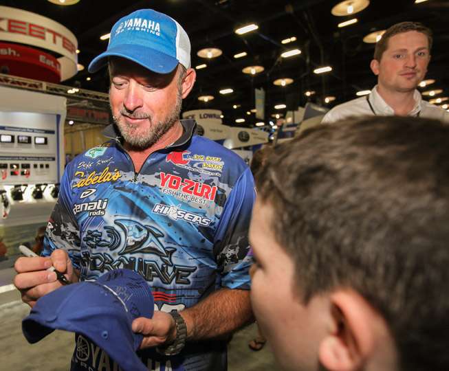 Jeff Kriet offers some advise to this young angler as he puts his mark on the fan's hat.
