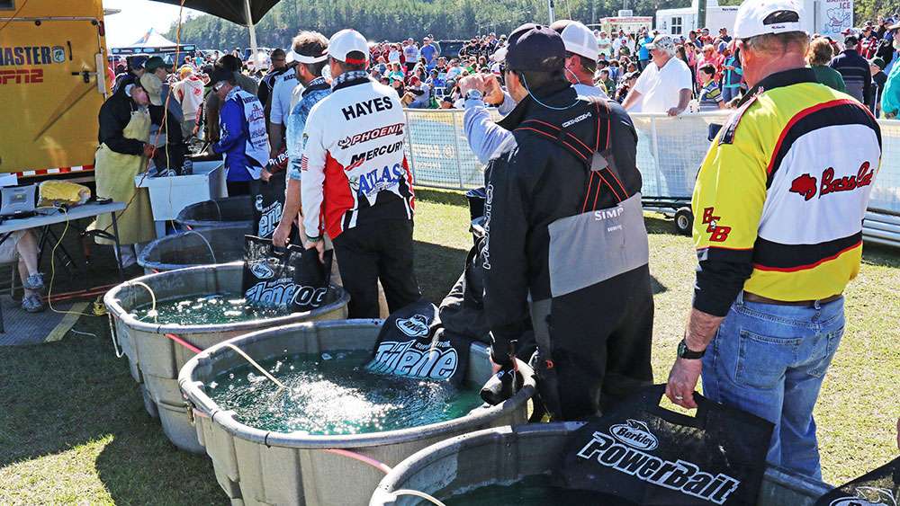 Each pro and co-angler must wait their turn to walk across the stage to have their day's catch officially weighed. 