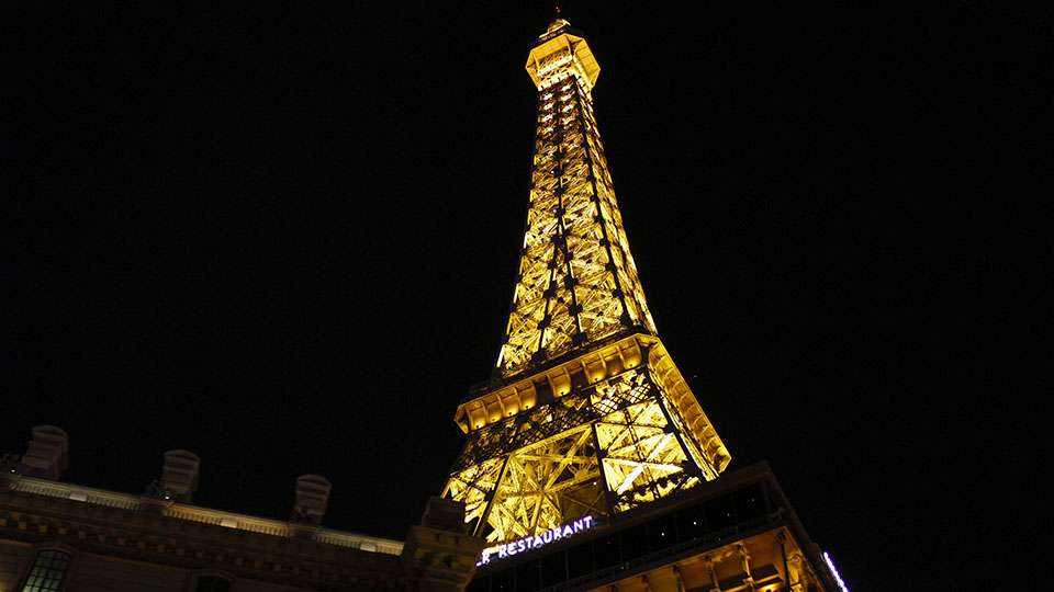 A replica Eiffel Tower stands tall on the strip.