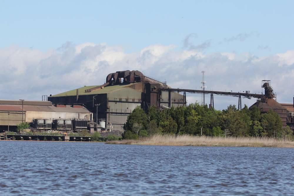 Massive industrial structures line certain sections of the shore. 