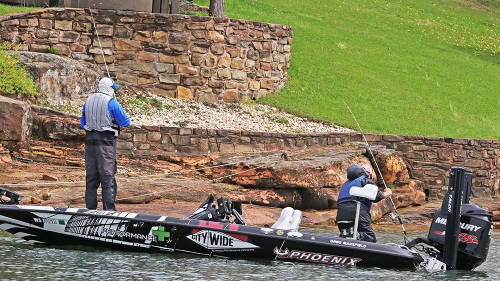 Down the lake is Greg Mansfield and his co-angler for the day Charlie Fachtman, who is wrestling a fish into the boat.