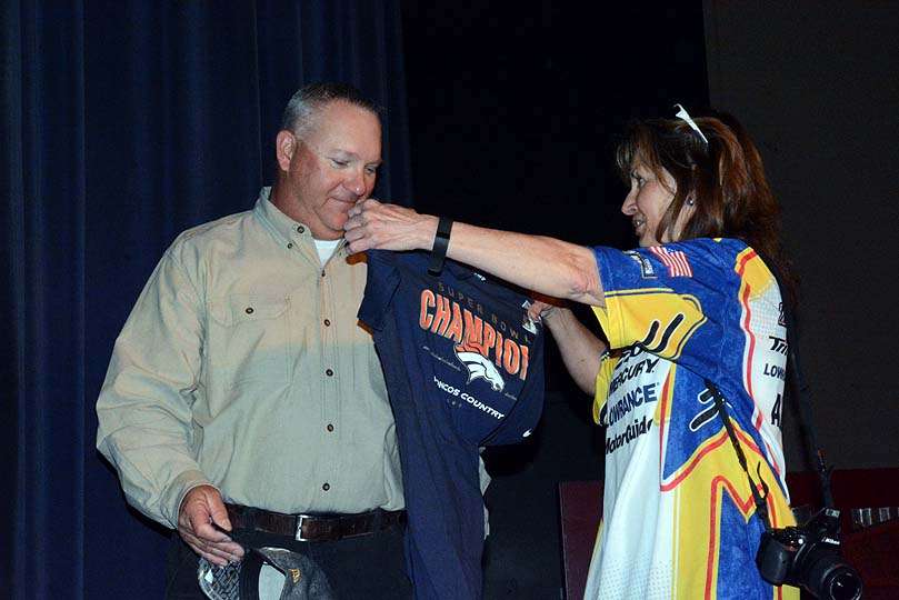 Audrey McKenney, president of the Colorado B.A.S.S. Nation, presents Jon Stewart with a Denver Broncos Super Bowl championship t-shirt and hat. 