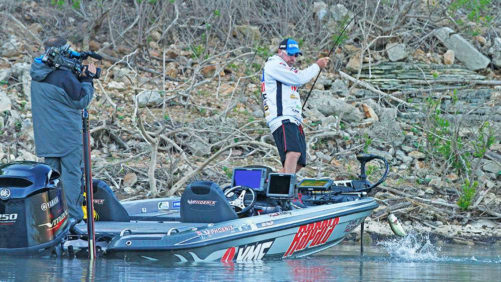 Tharp flips the bass into the boat, but will it measure? Too small, and it goes back. 