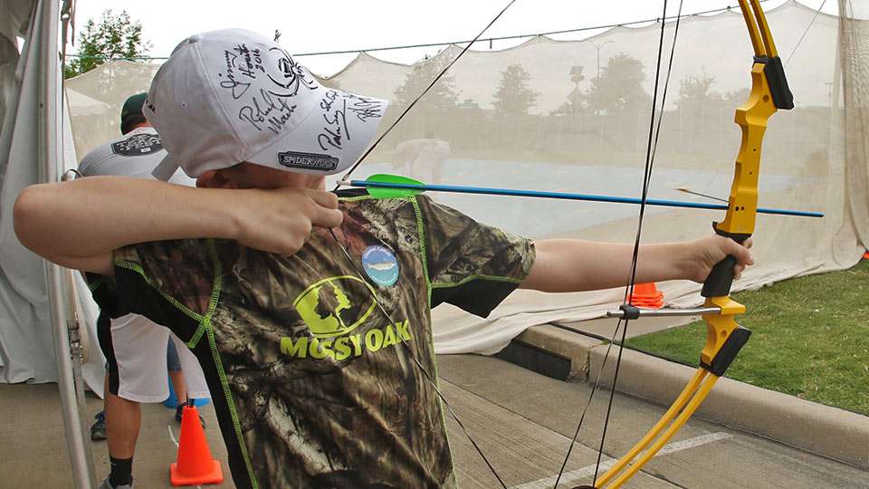 Austin draws back at the Get Outside booth, which was partnered with the National Archery in Schools Program.